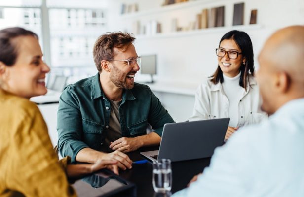 a group of people looking at a laptop