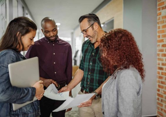 a group of people looking at a laptop