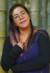 a woman wearing glasses and smiling at the camera