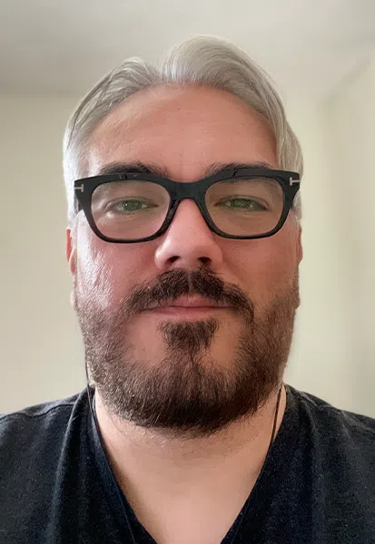 a man wearing glasses and looking at the camera