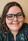 a woman wearing glasses and smiling at the camera