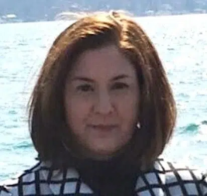 a person smiling next to a body of water